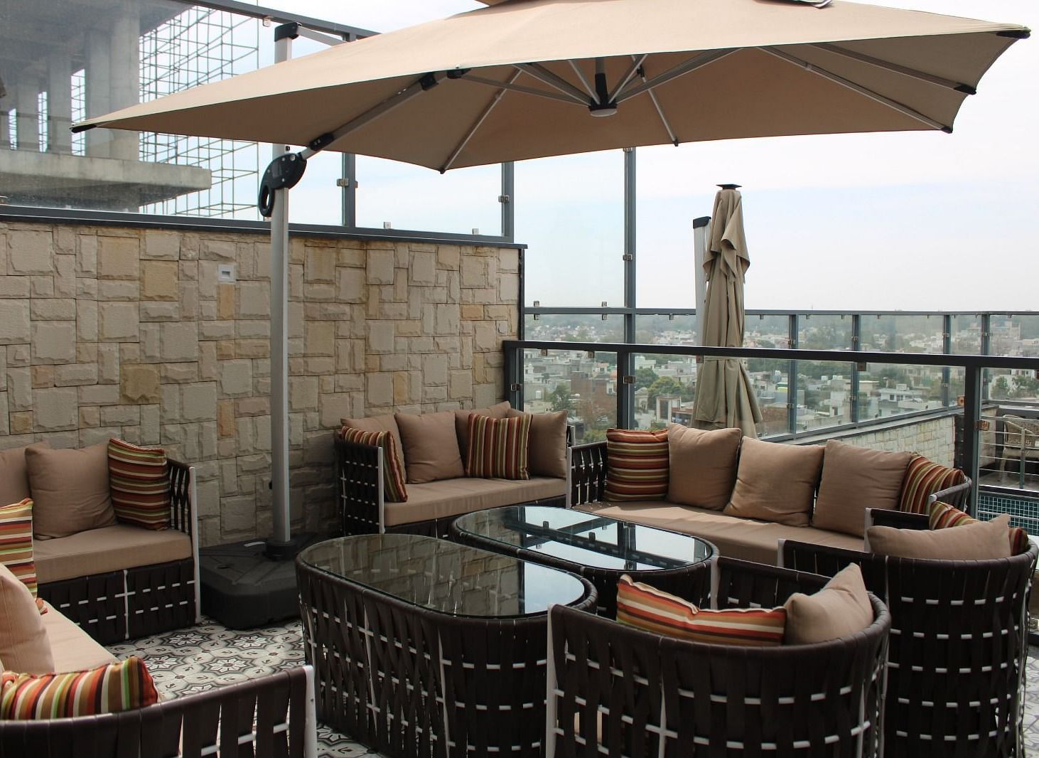Rooftop lounge featuring sofas, pillows, and a patio offering stunning city views at BluSalzz Residence, Amritsar